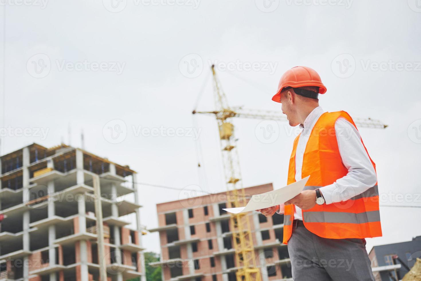 arquitetura e conceito de renovação doméstica - homem de capacete e luvas com planta na fábrica foto