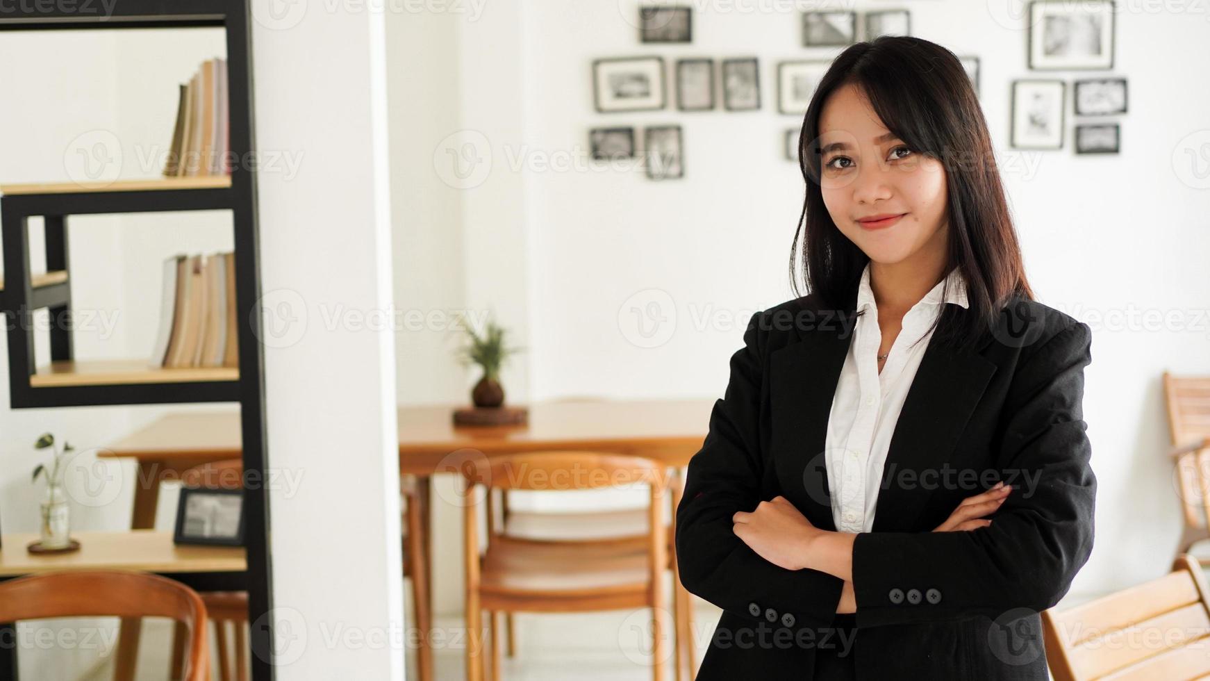 bela jovem mulher de negócios asiáticos de terno em pé no café foto
