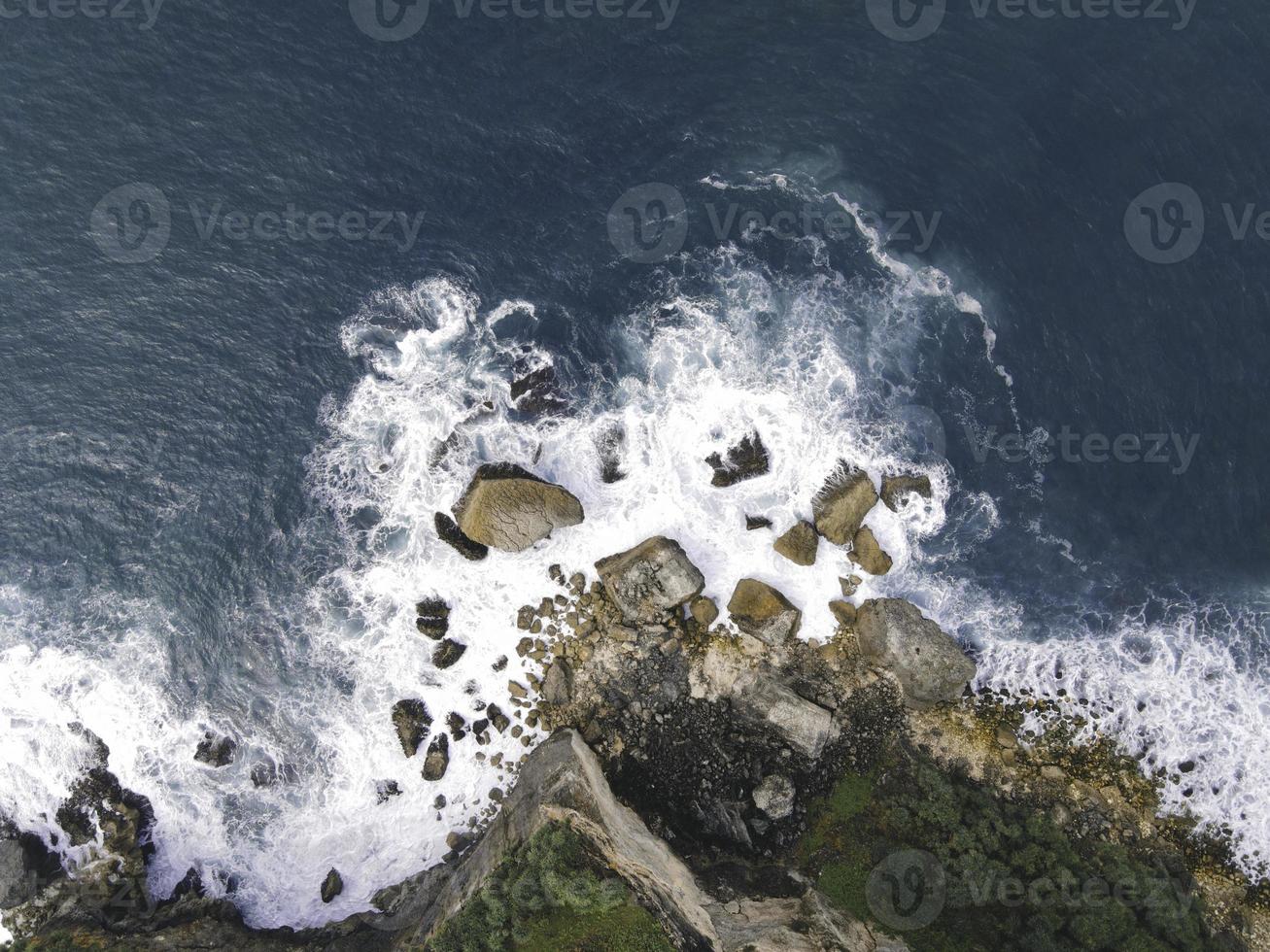 vista aérea de cima para baixo de ondas gigantes do oceano batendo e espumando na praia de coral foto