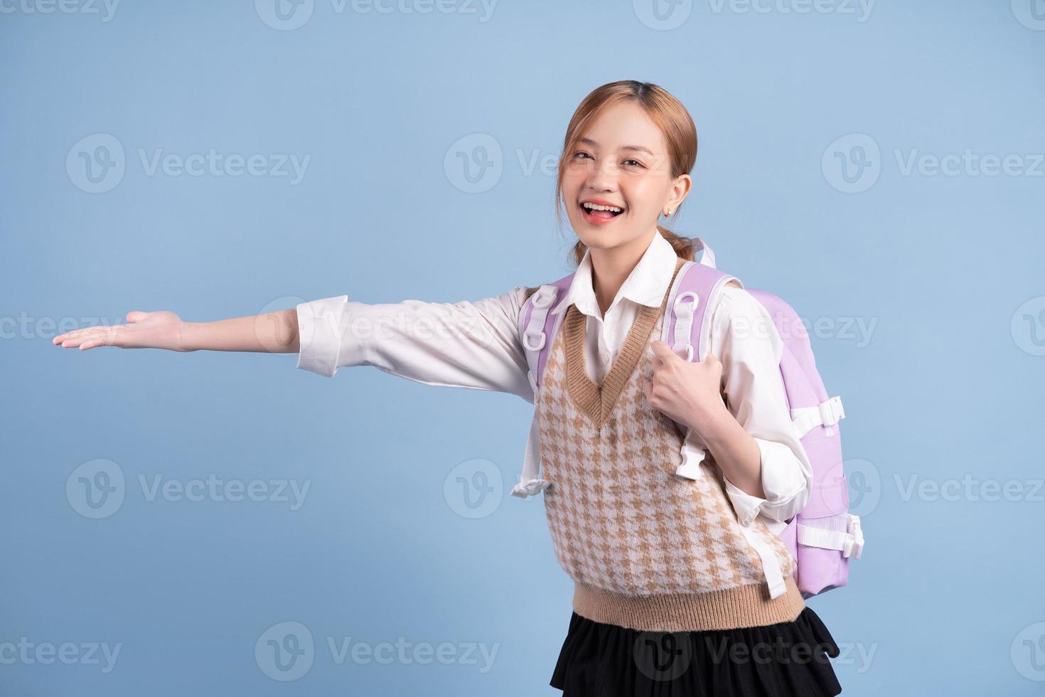 jovem colegial asiática em fundo azul foto