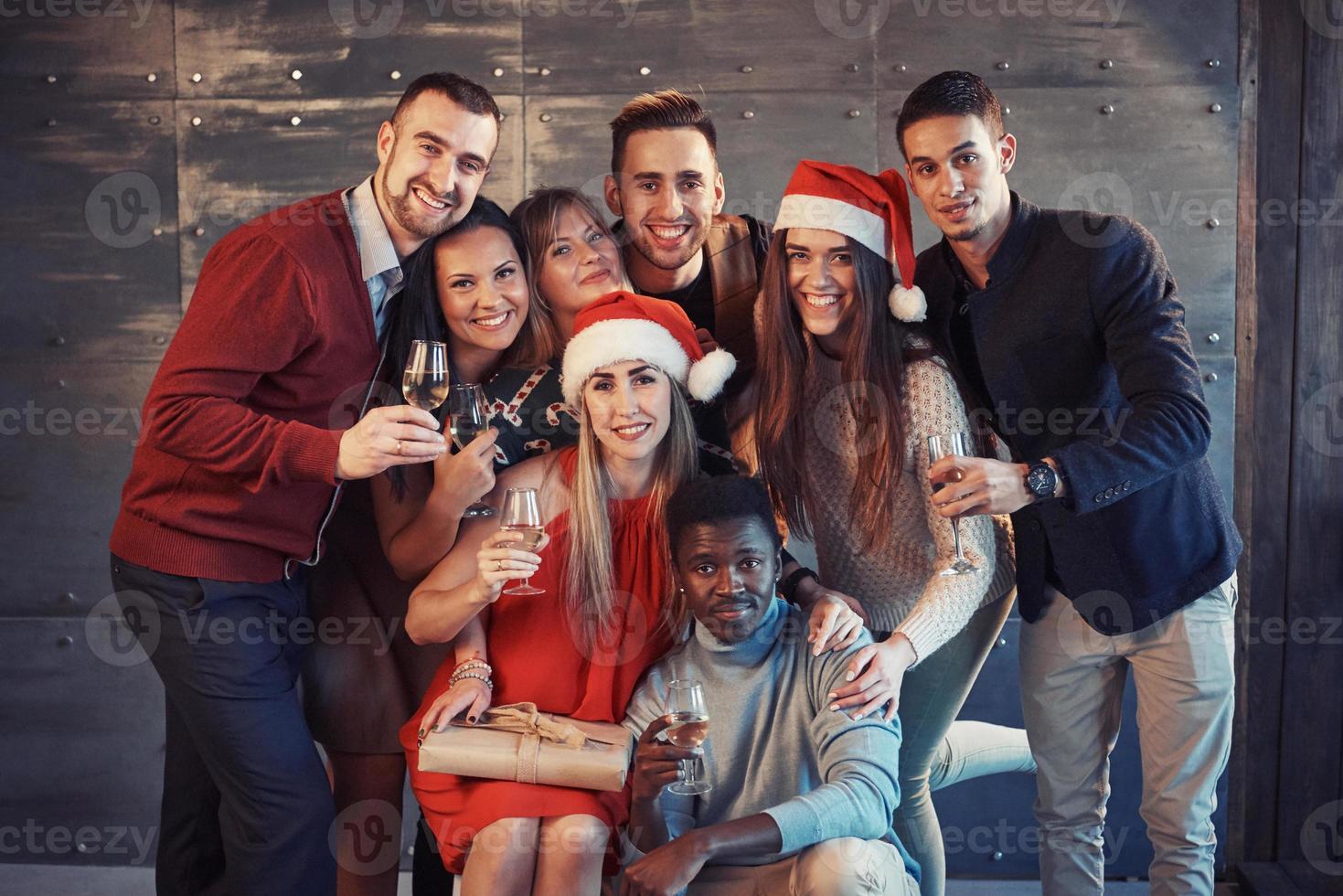 ano novo está chegando. grupo de jovens multiétnicos alegres com chapéu de Papai Noel na festa, posando de conceito de pessoas de estilo de vida emocional foto