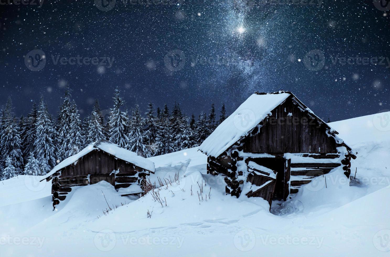 noite com estrelas. paisagem de natal. casa de madeira na aldeia de montanha. paisagem noturna no inverno foto
