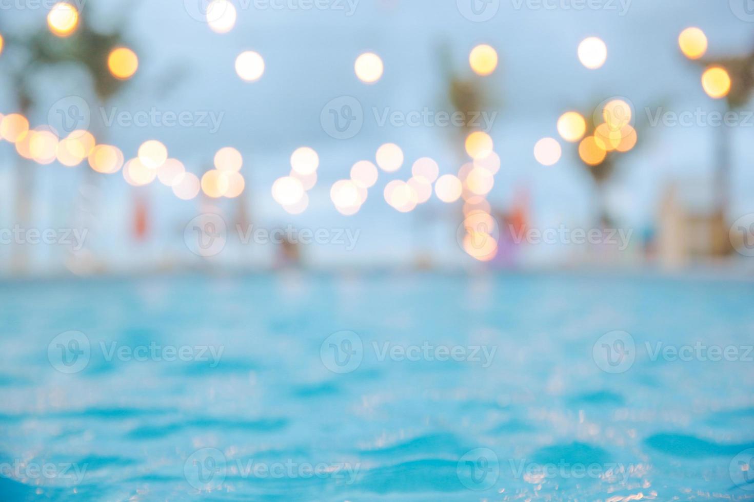 luz desfocada do bokeh no fundo abstrato da água azul da piscina do verão foto