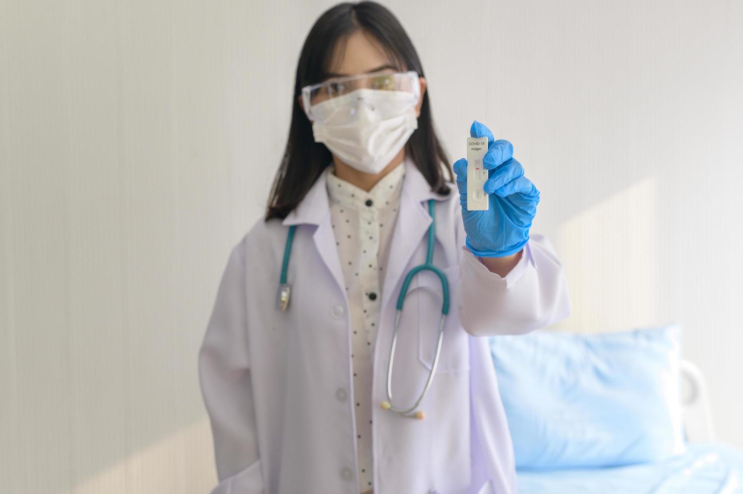 jovem médica segurando kit atk no hospital, covid19 e conceito de pandemia foto