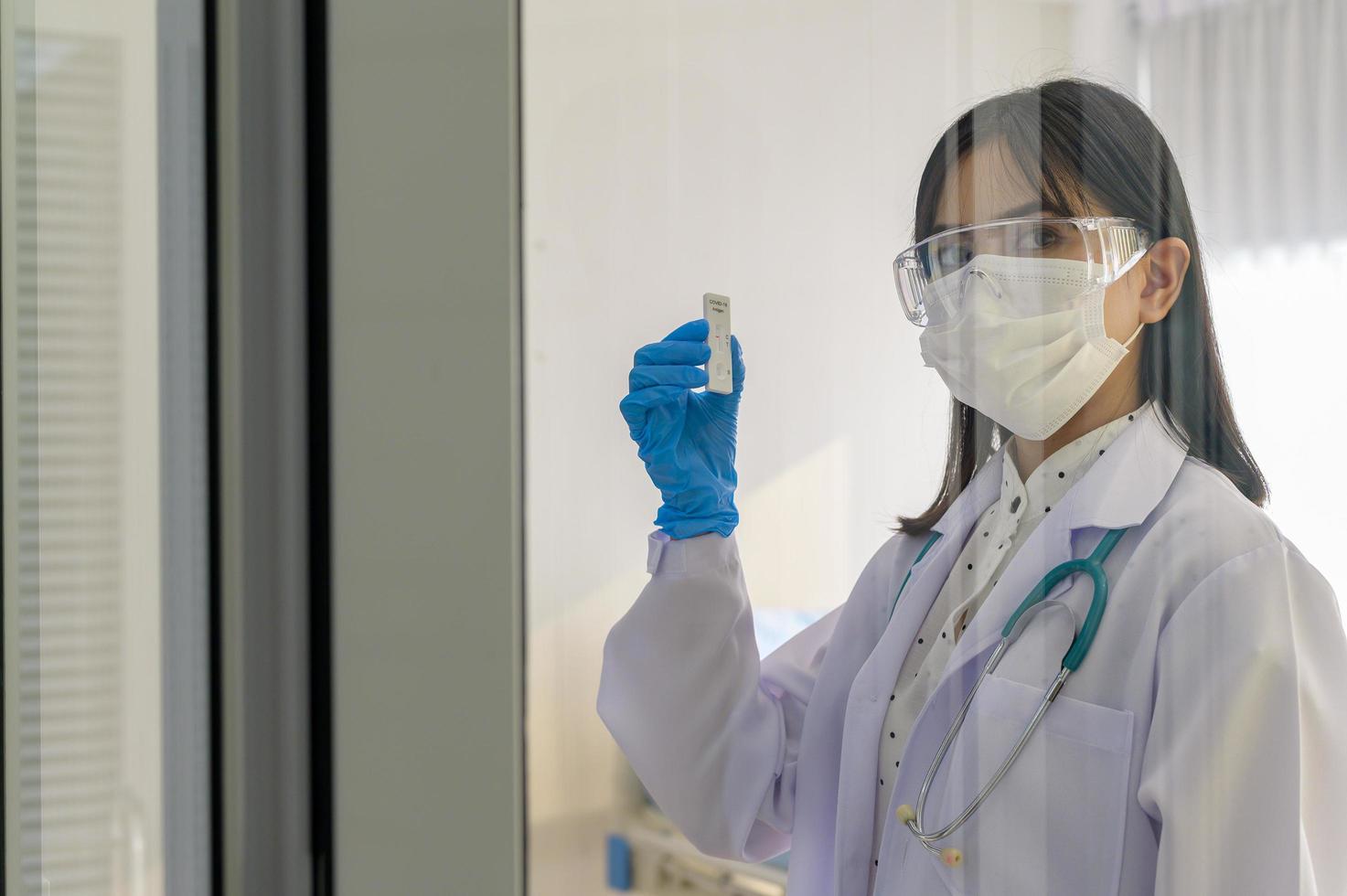 jovem médica segurando kit atk no hospital, covid19 e conceito de pandemia foto