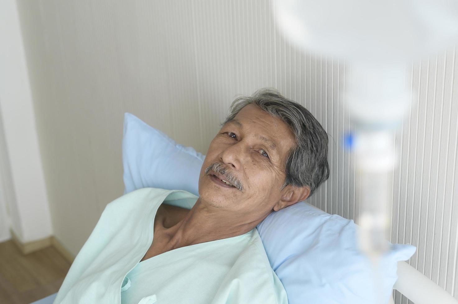 retrato de paciente sênior deitado na cama no hospital, cuidados de saúde e conceito médico foto