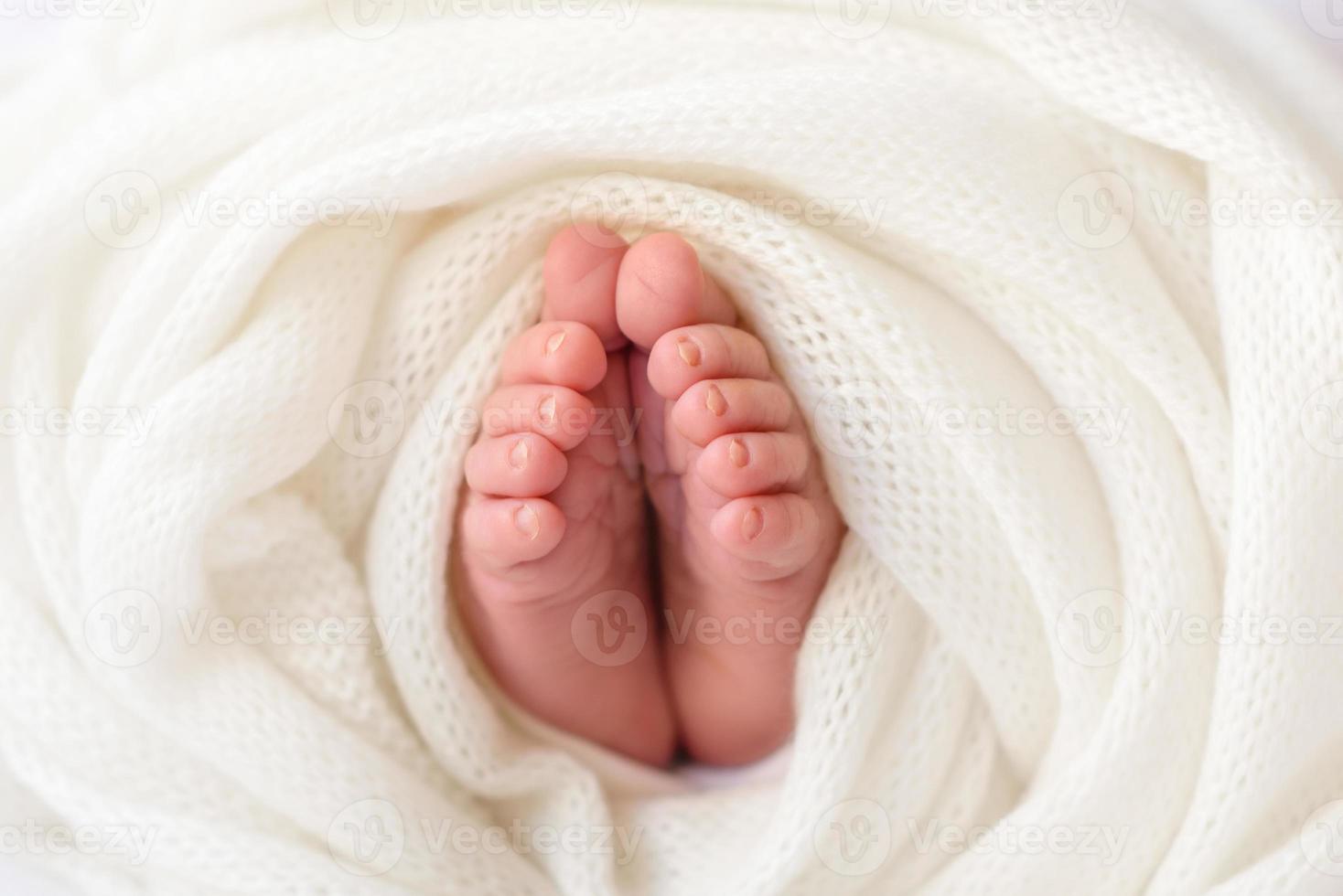 pequenas belas pernas de um bebê recém-nascido nos primeiros dias de vida foto