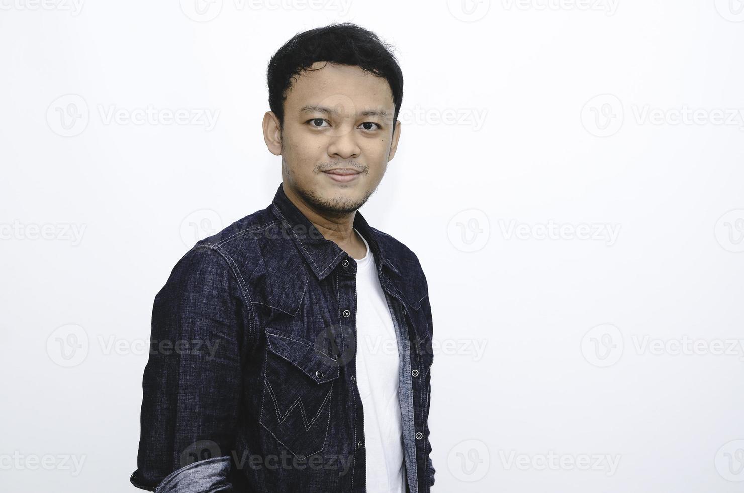 retrato de sorridente jovem asiático vestindo camisa branca e calça jeans isolada no branco. foto