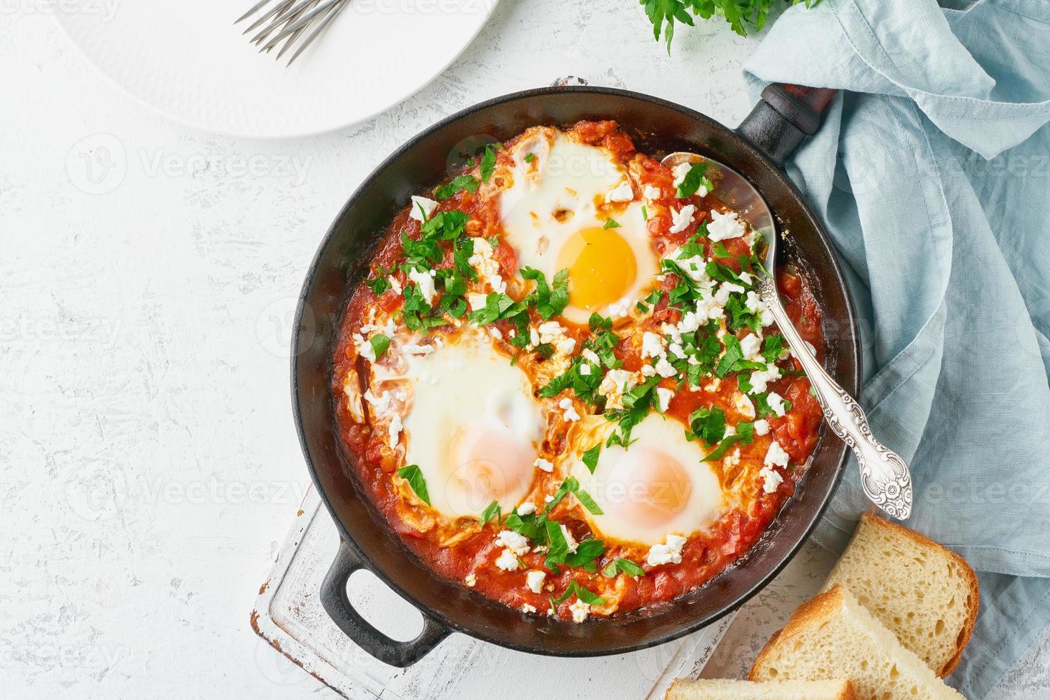 shakshouka, ovos escalfados em molho de tomate, azeite. cozinha mediterrânea. foto