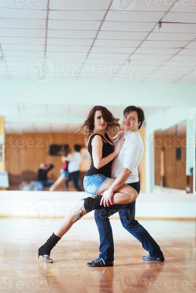lindo casal de artistas profissionais dançando dança apaixonada foto