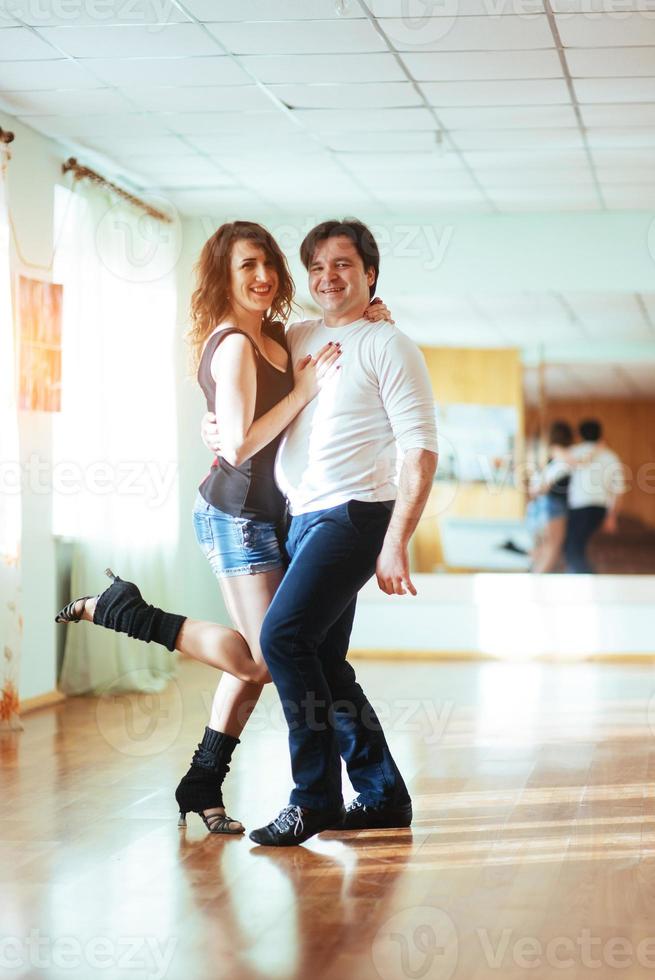 lindo casal de artistas profissionais dançando dança apaixonada foto