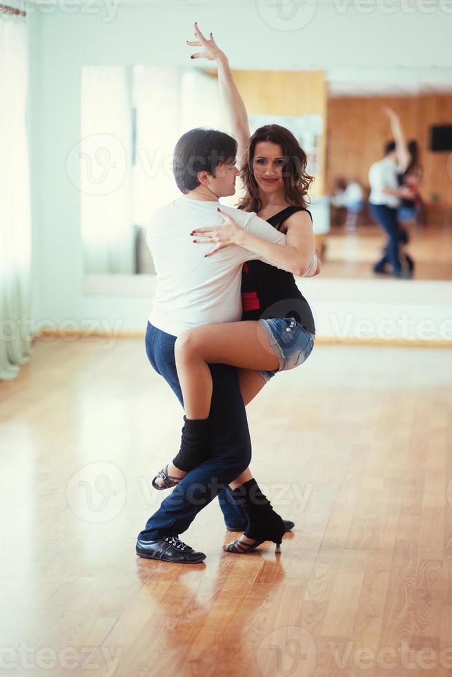 lindo casal de artistas profissionais dançando dança apaixonada foto