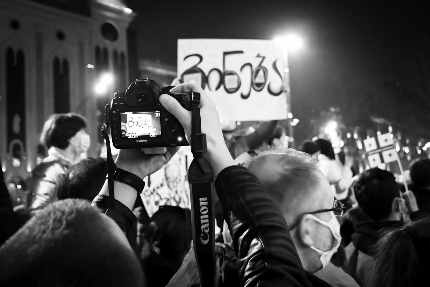 Tbilisi, Geórgia, 2022 - fotógrafo tira foto de cartaz em protesto