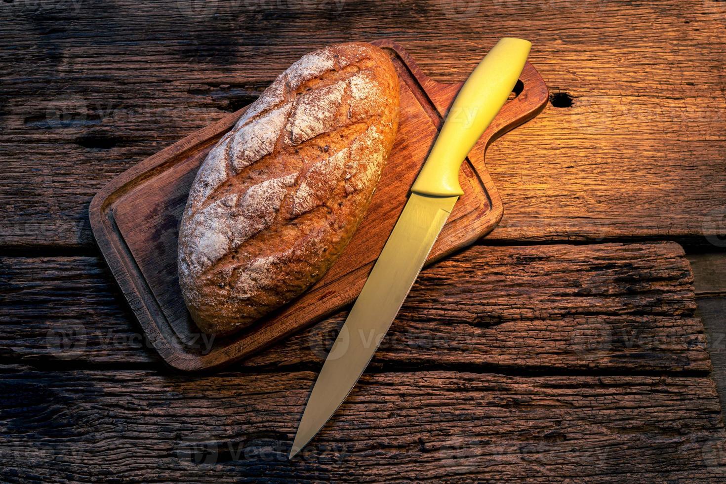 pão baguete isolado em fundo de madeira foto