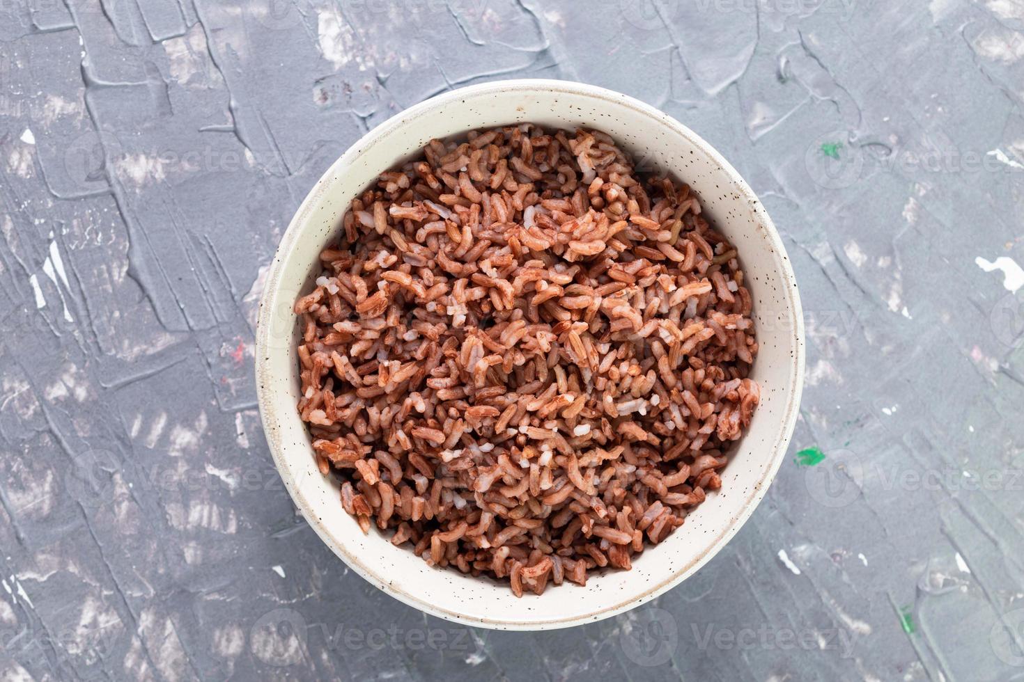 arroz vermelho em tigela isolada em fundo cinza comida asiática cozida. foto