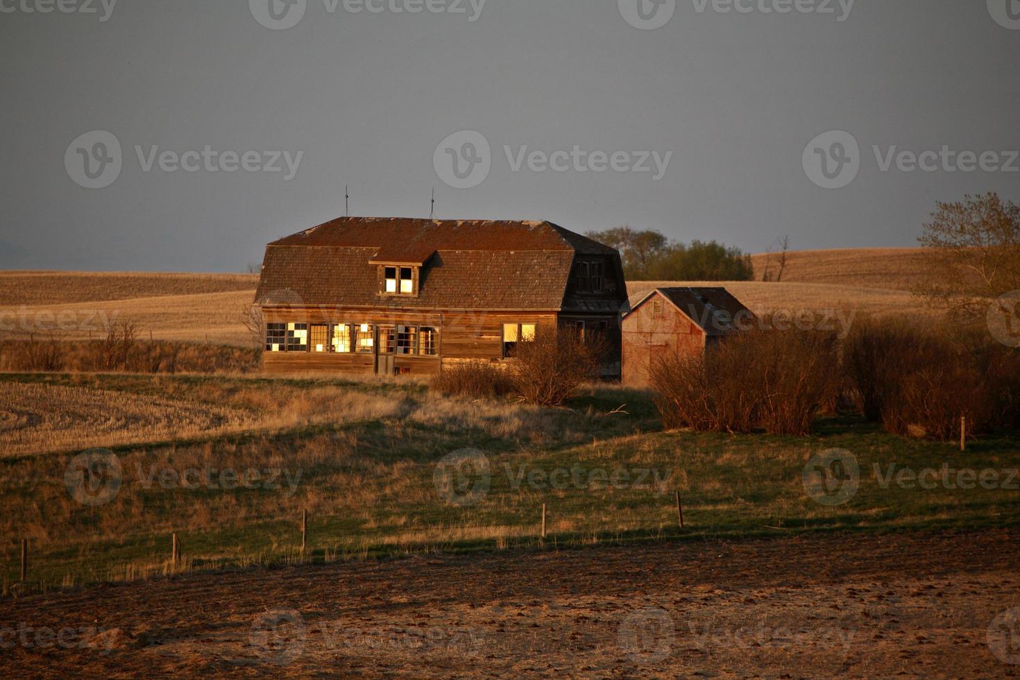 casa de fazenda deserta ao pôr do sol em saskatchewan foto