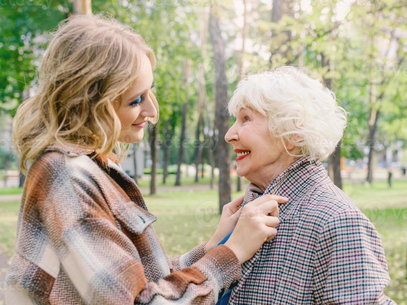 mulher sênior com filha andando ao ar livre na primavera. família, geração, cuidado, amor, conceito de vacinação foto