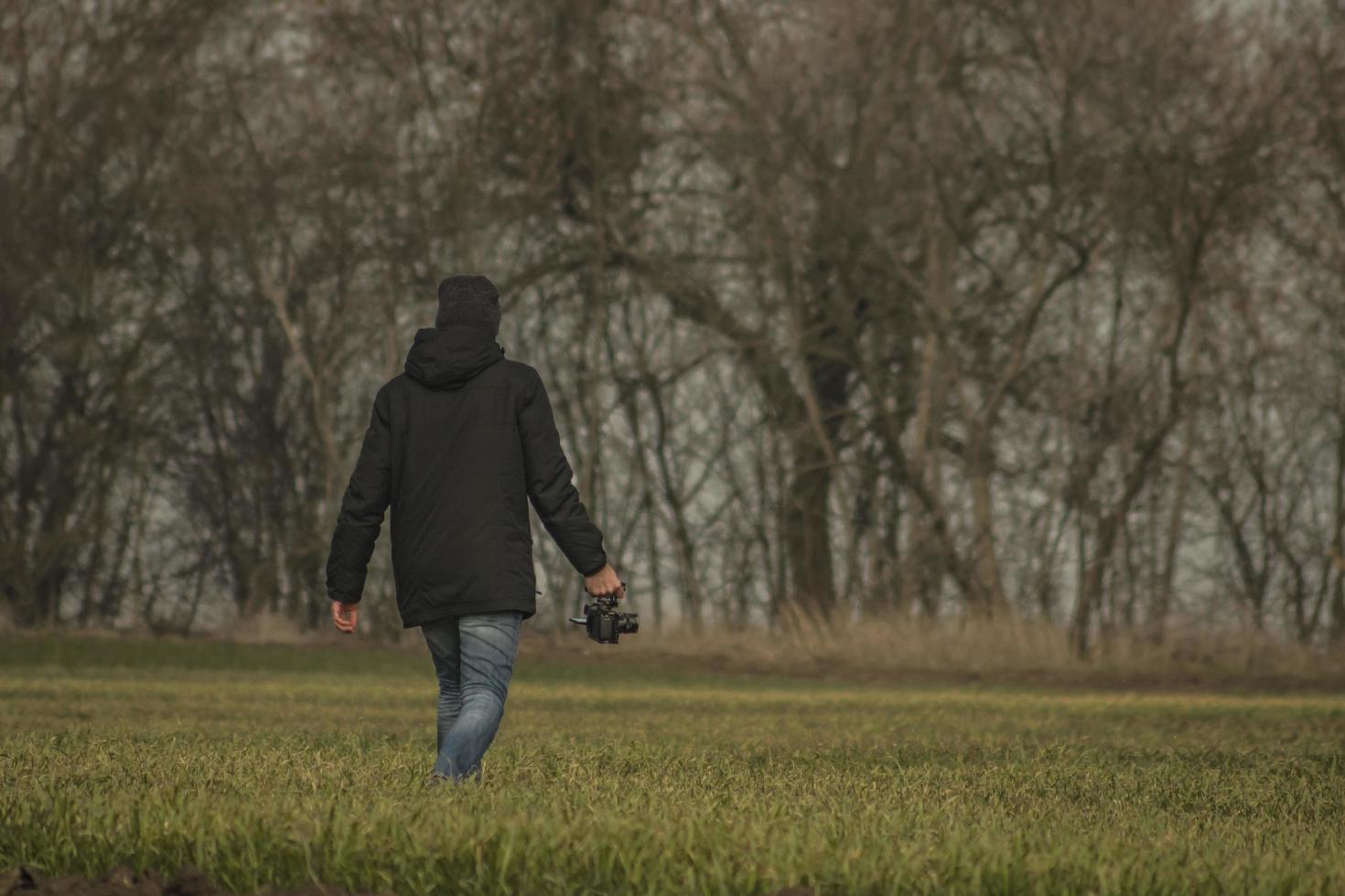 um homem com uma câmera está andando no campo foto