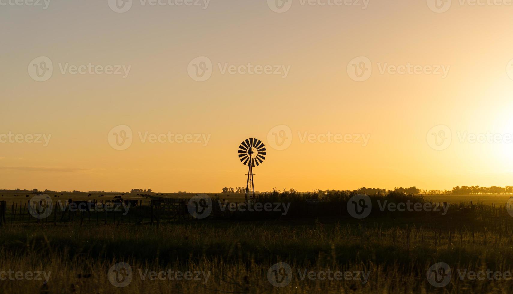 moinho de vento rural isolado ao pôr do sol foto