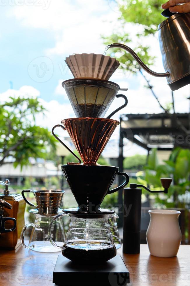 barista experimentando novos sabores de café por gotejamento empilhando o gotejador como uma torre. foto