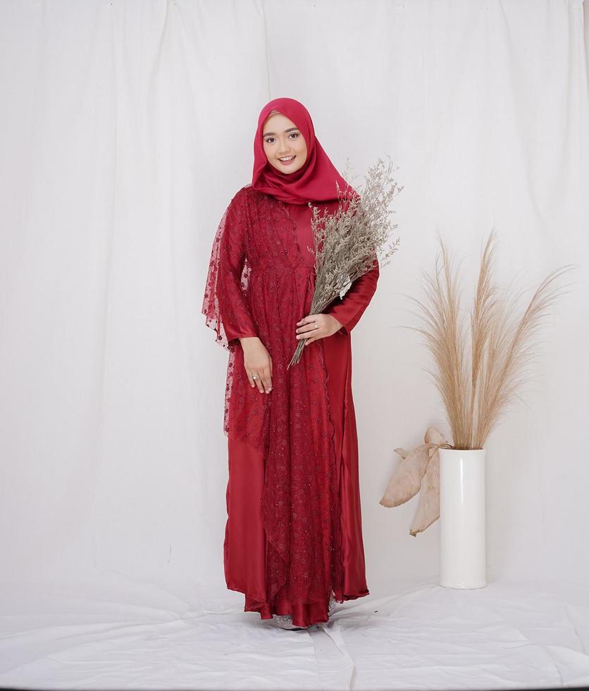 bela modelo feminino islâmico vestindo a moda hijab, uma roupa de estilo de vida moderno para a mulher muçulmana. conceito de vestido de noiva, beleza ou eidul fitri. uma modelo asiática usando hijab em uma sessão de fotos interna