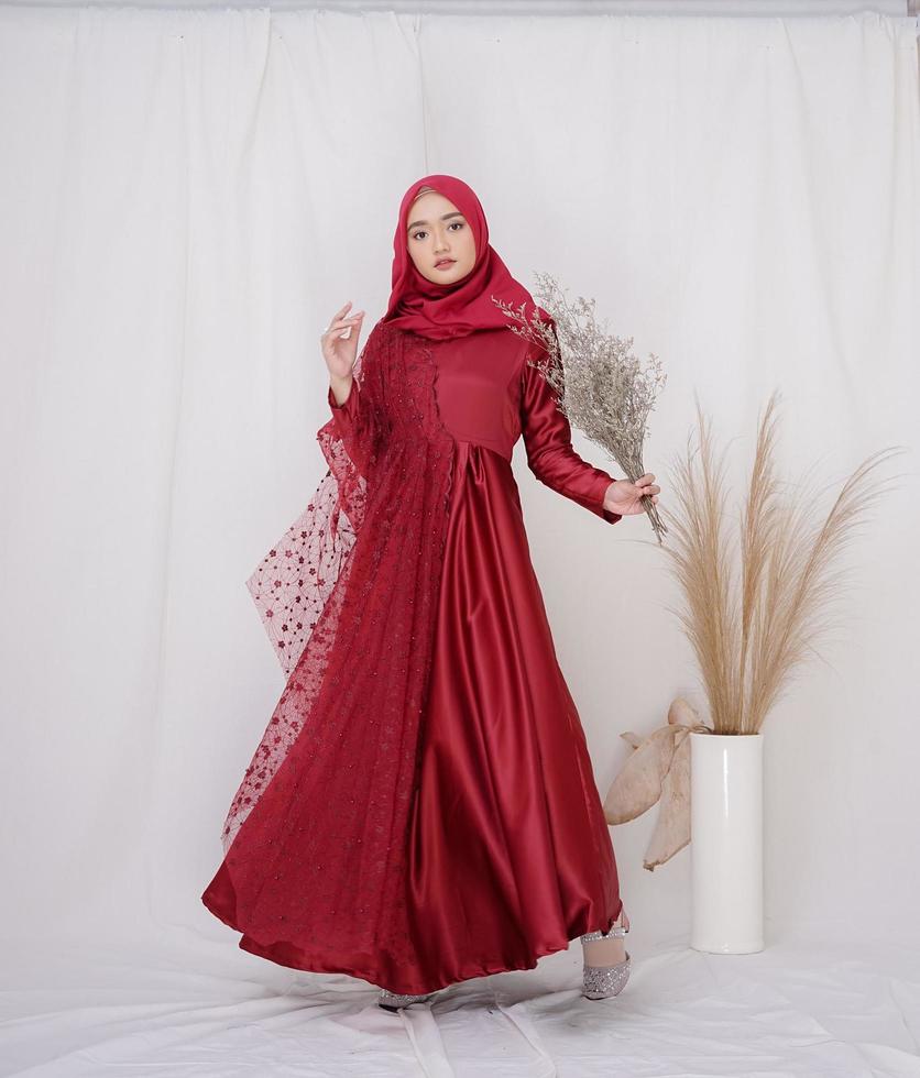 bela modelo feminino islâmico vestindo a moda hijab, uma roupa de estilo de vida moderno para a mulher muçulmana. conceito de vestido de noiva, beleza ou eidul fitri. uma modelo asiática usando hijab em uma sessão de fotos interna