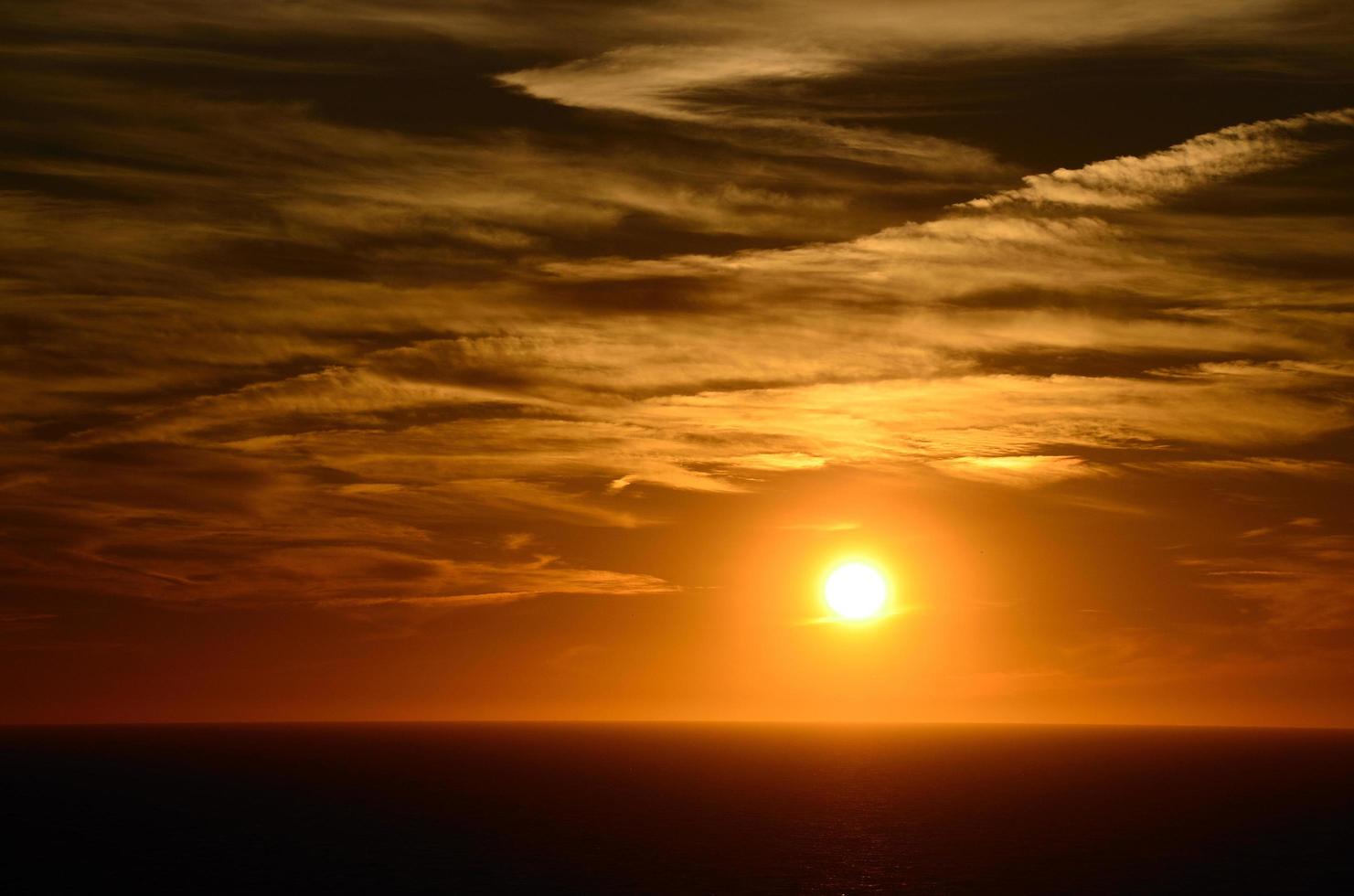 belo pôr do sol quente no mar foto