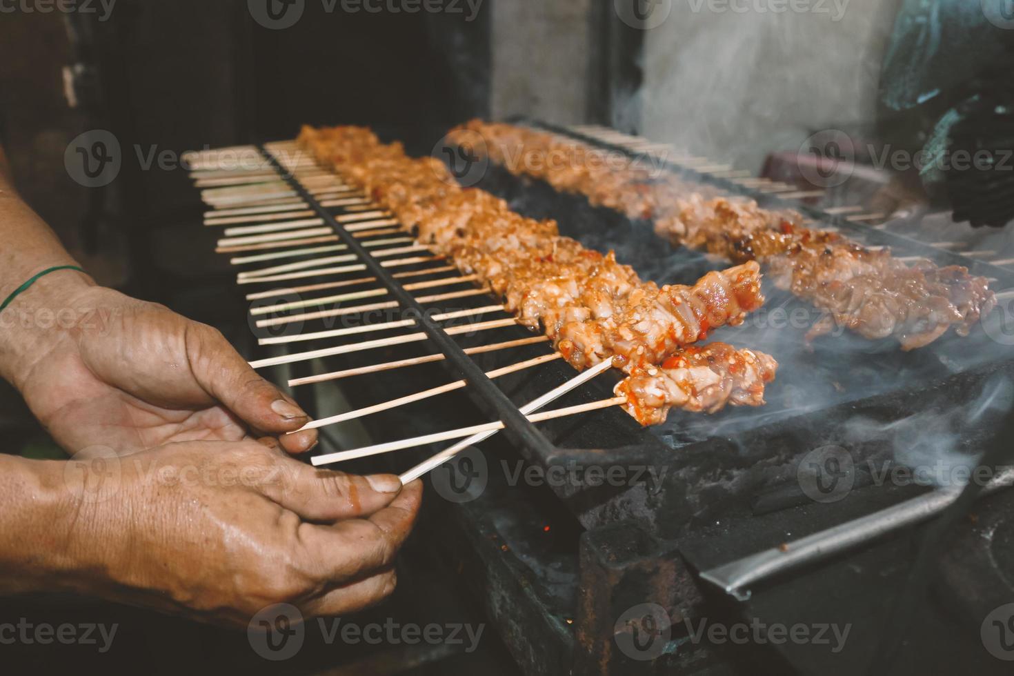 satay de frango ou satay de pele de frango é espetos de frango grelhados marinados com especiarias e molho de pimenta vermelha foto