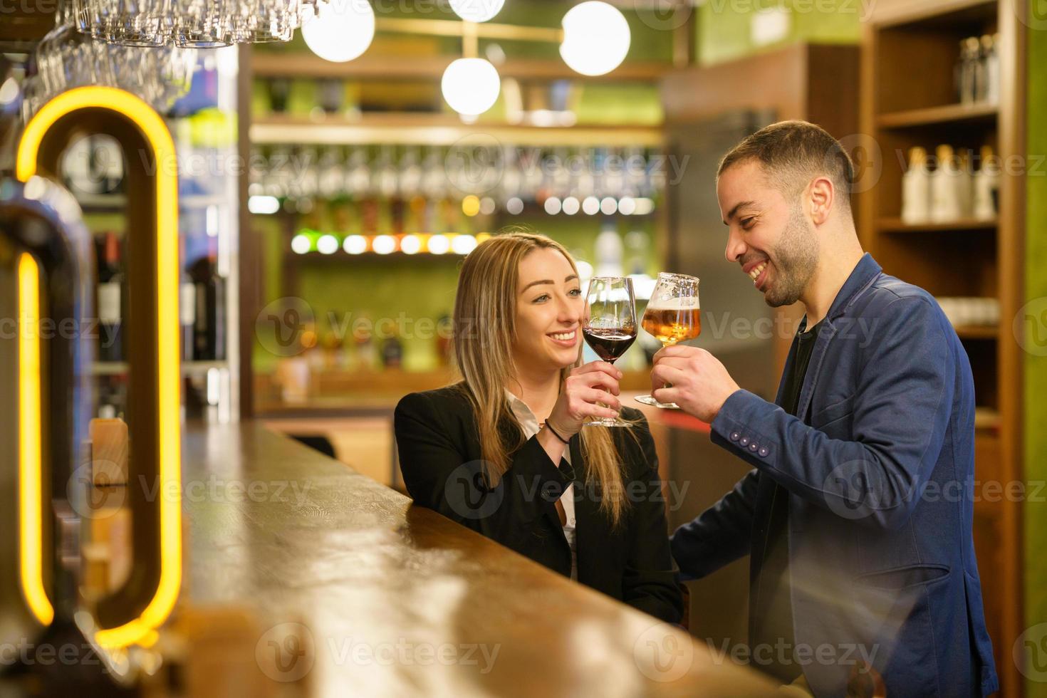 casal multiétnico propondo brinde em um pub foto