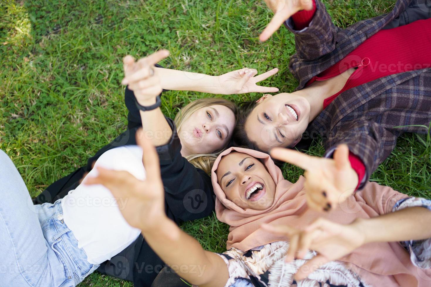 felizes diversas mulheres deitadas no gramado foto