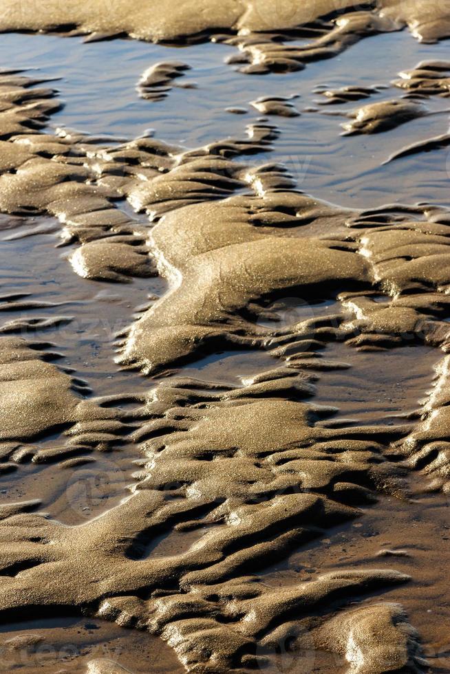 areia após a maré baixa em uma praia na cantábria, espanha. imagem vertical. foto