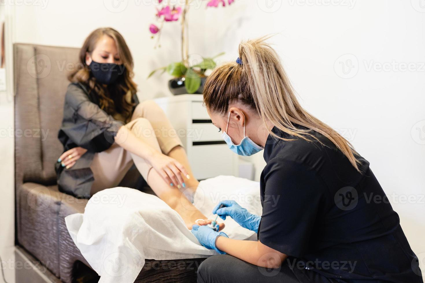 esteticista fazendo pedicure pintando as unhas de sua cliente em um centro de beleza. foto