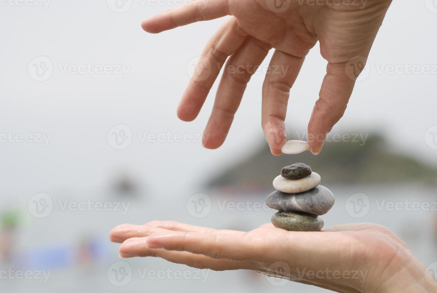 pilha de cascalho nas mãos da mulher com fundo do mar foto