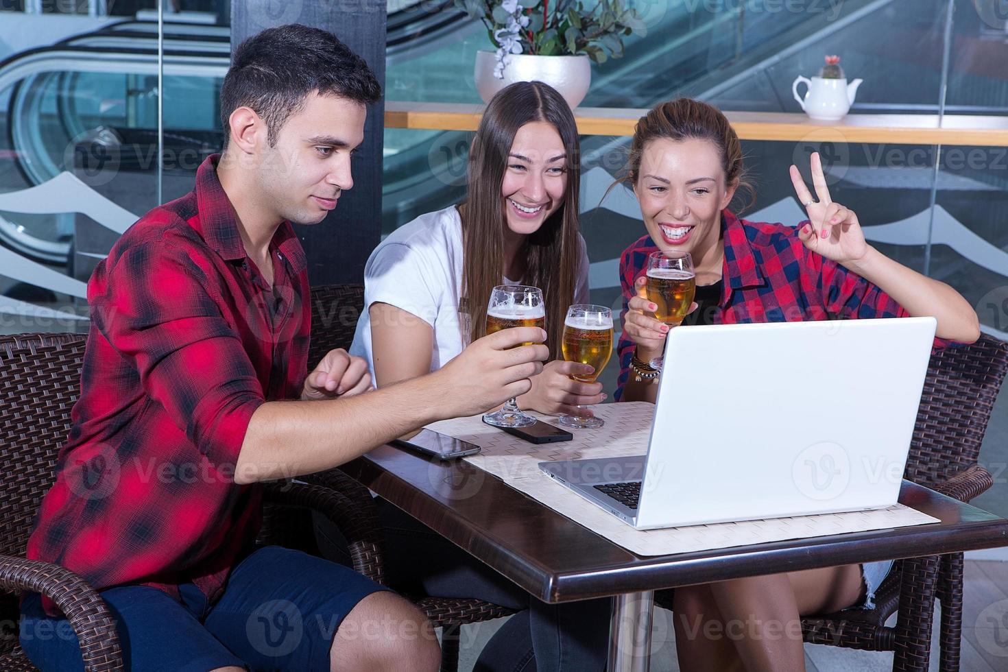 amigos no pub com laptop foto