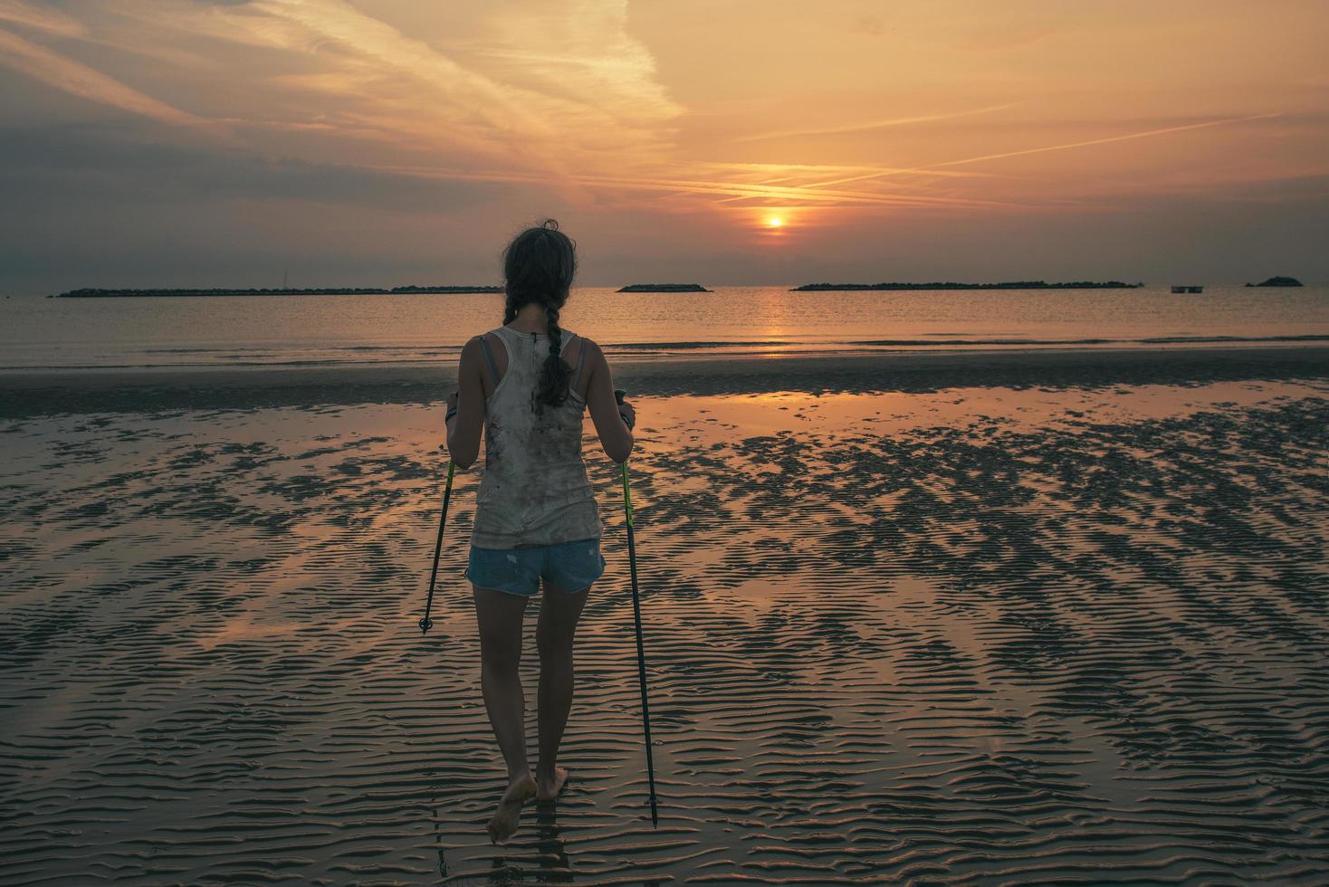 mulher faz atividade física na praia ao amanhecer foto