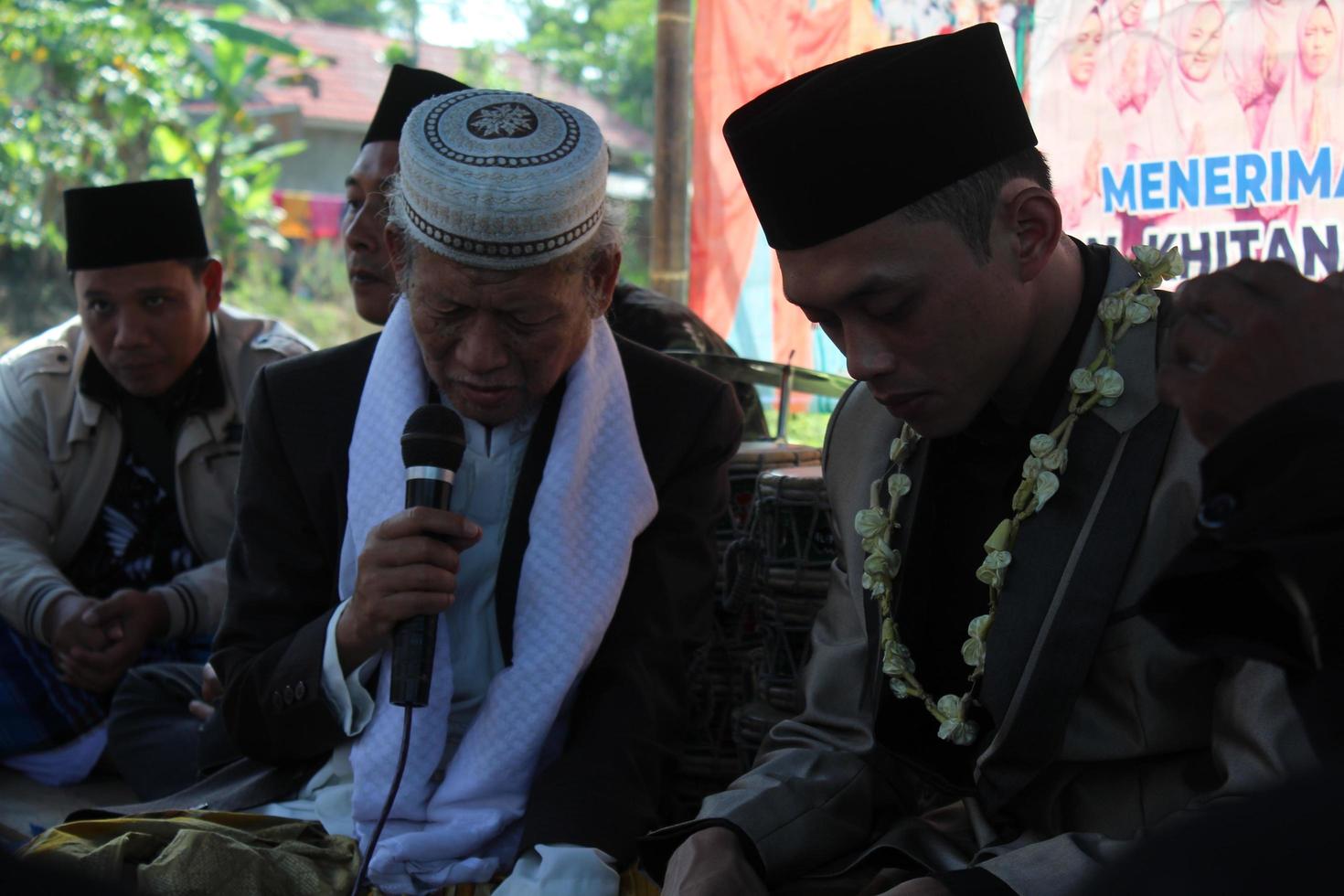 12 de junho de 2021 no distrito de Cianjur, West Java, Indonésia. um velho está aconselhando o noivo antes do casamento. costumes e cultura do casamento muçulmano indonésio. foto