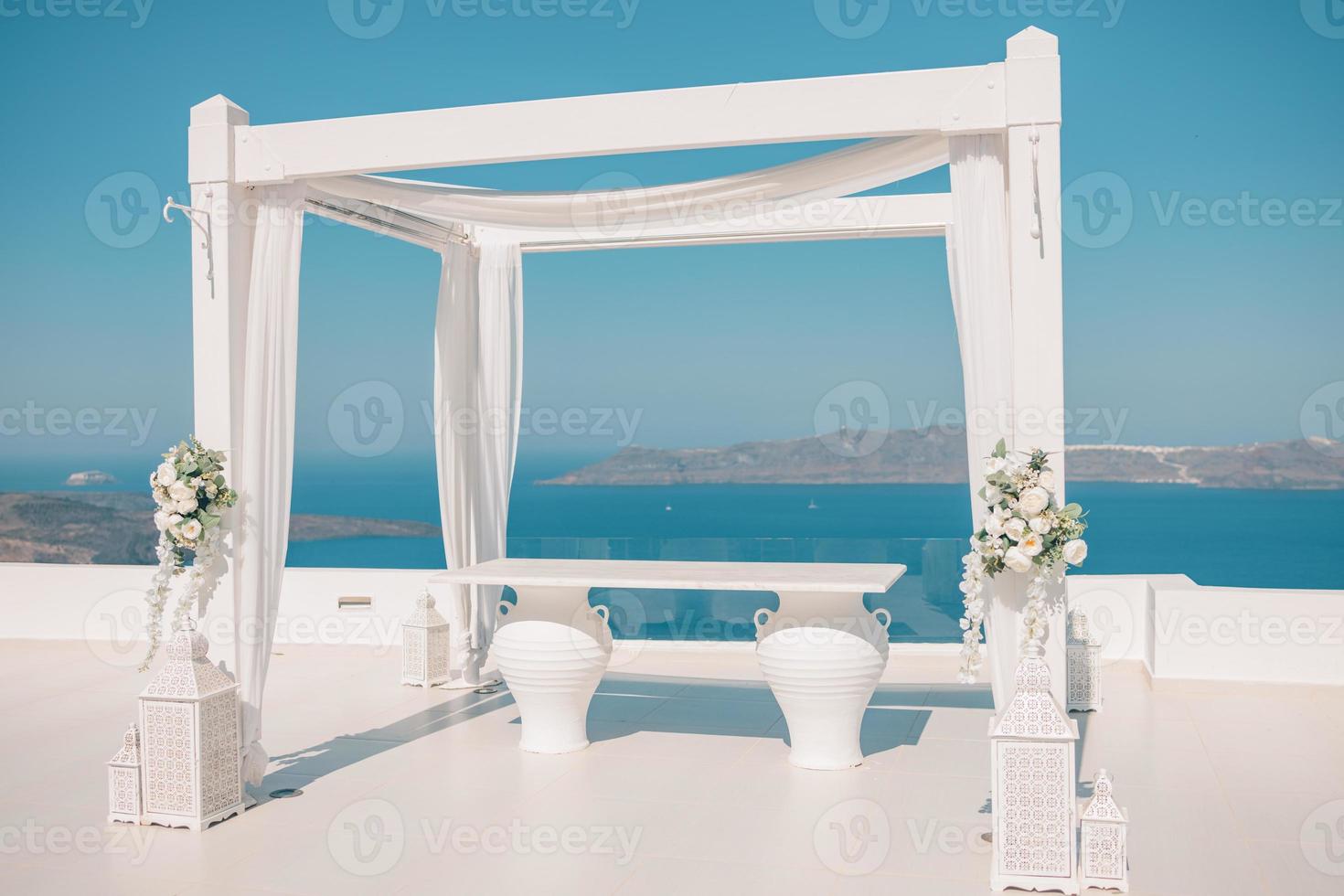 linda tenda de casamento na ilha de santorini. decorações de casamento com rosas no fundo do mar, grécia, santorini. casamento de destino romântico, conceito de romance foto