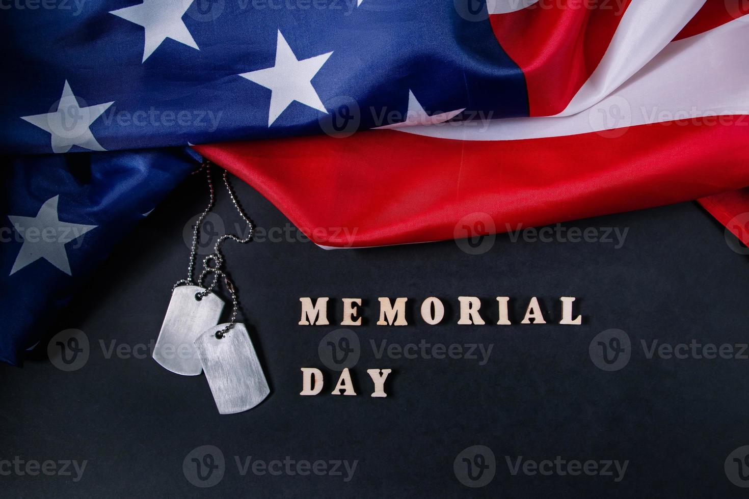 conceito de dia memorial. bandeira americana e placas de identificação militar em fundo preto foto