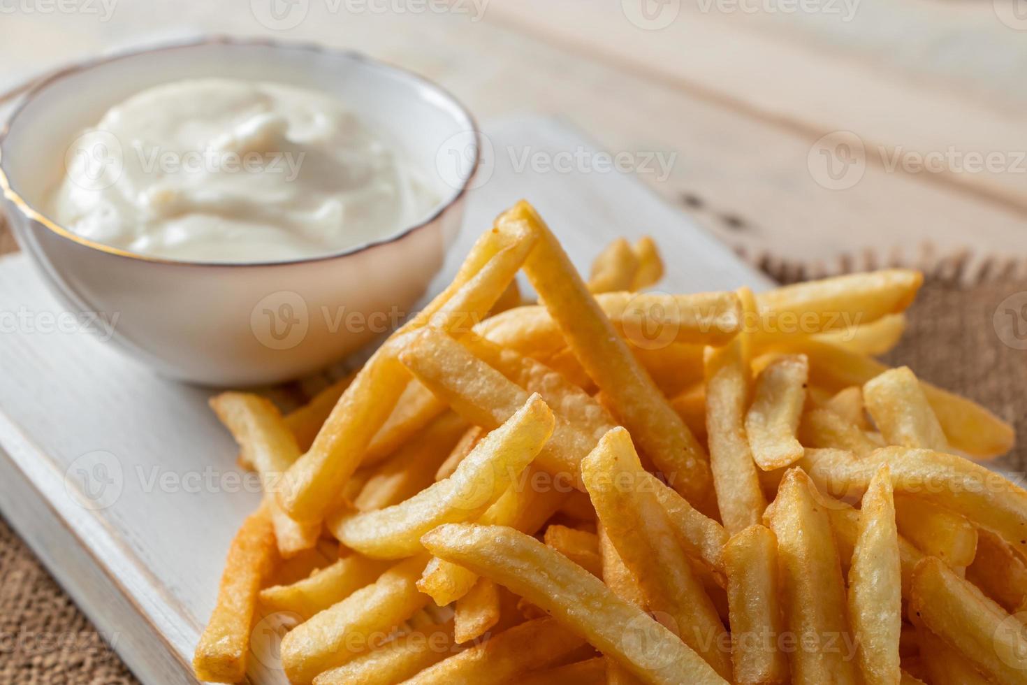 batatas fritas douradas quentes com ketchup em um fundo de madeira. foto