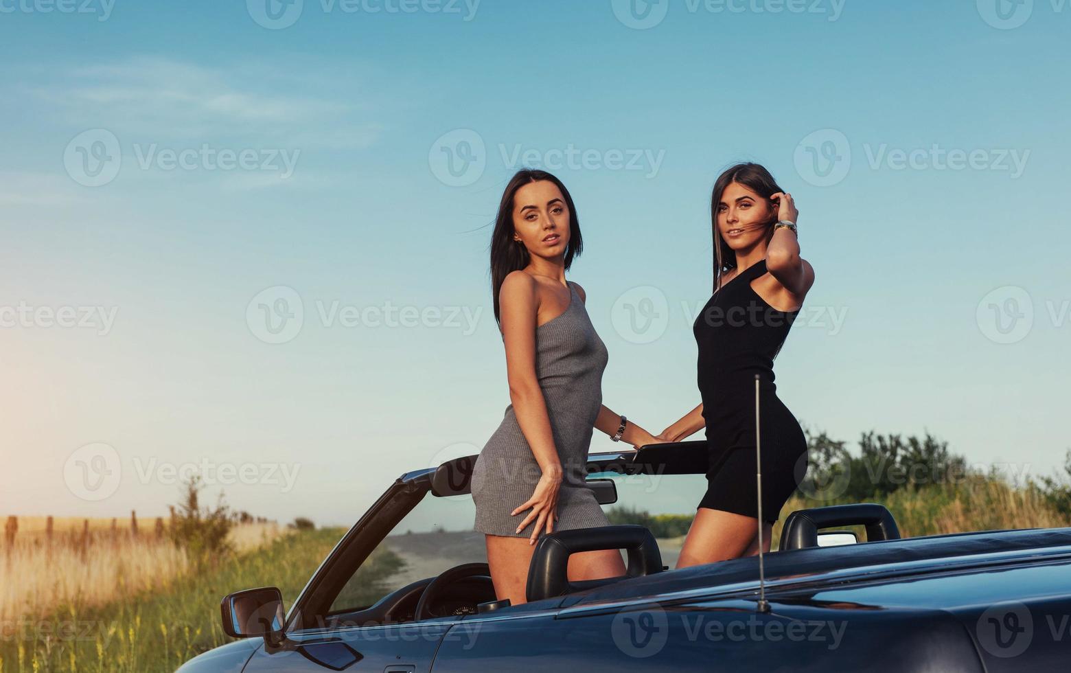 lindas duas mulheres sentadas em um conversível foto