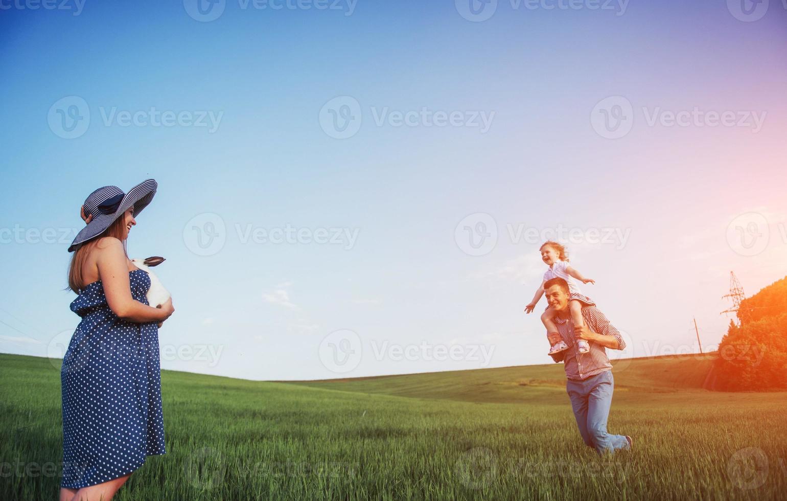 família feliz de três pessoas abraçando nas ruas foto