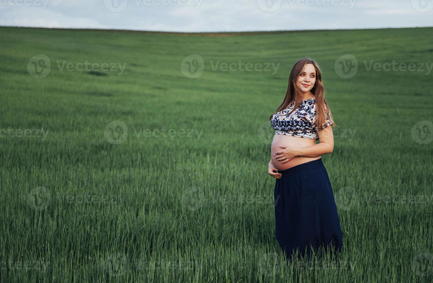 mulher grávida no campo de trigo verde foto