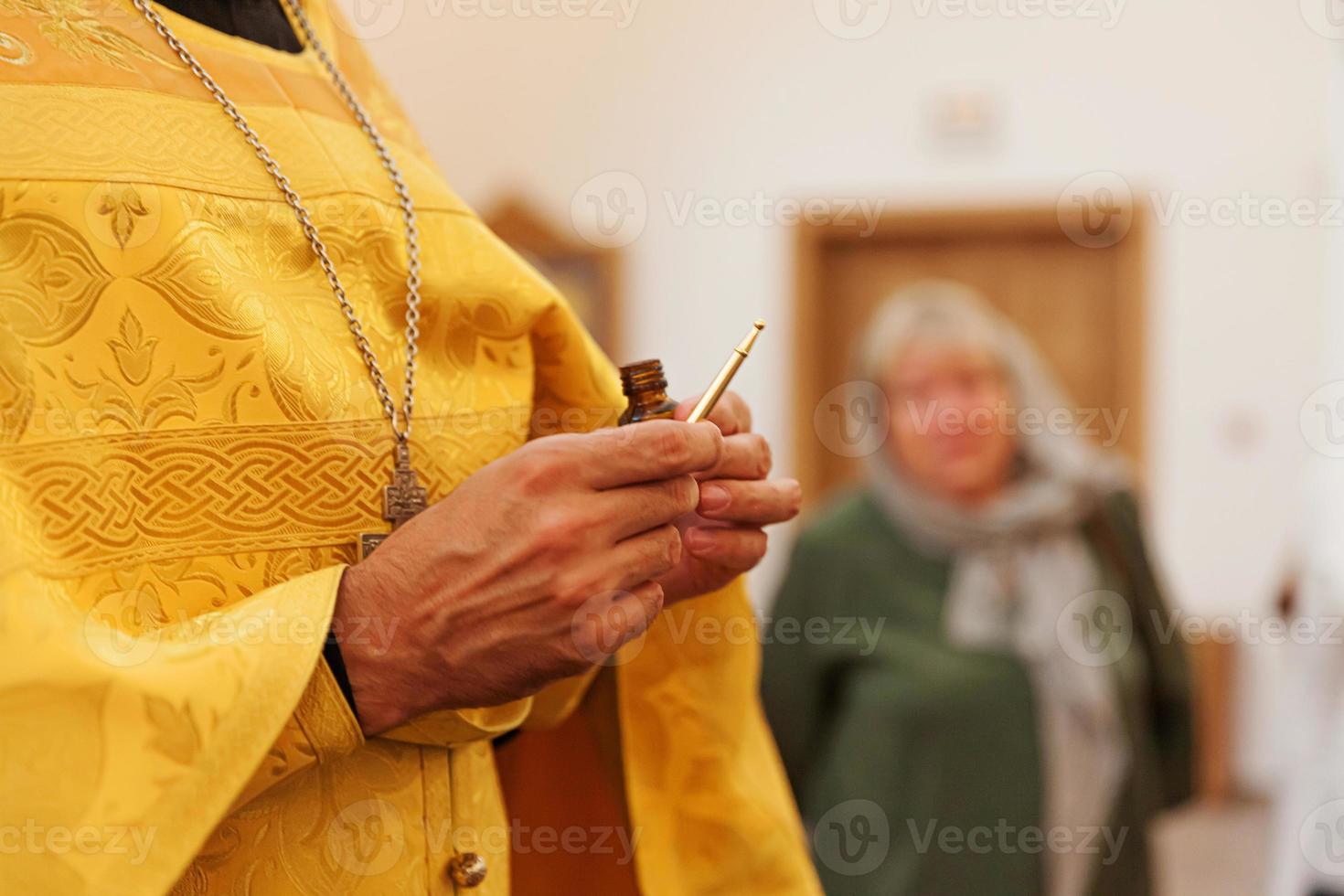 Igreja Ortodoxa. cristandade. mãos de padre segurando óleo para unção no batismo no fundo tradicional da igreja ortodoxa. religião fé rezar símbolo. celebração do batismo ortodoxo. foto