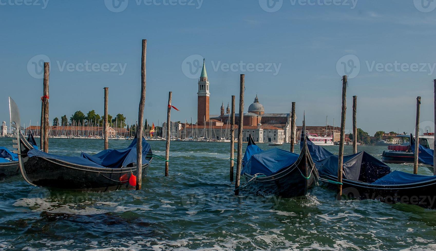 cliente de gôndolas à espera ancorado em veneza foto