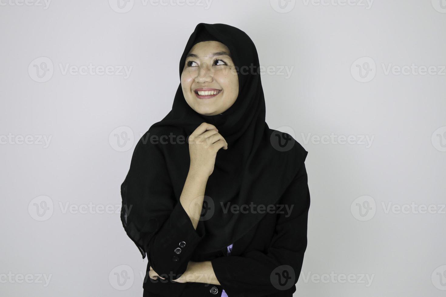 gesto feliz e sonhando acordado jovem mulher islâmica asiática usando lenço na cabeça. foto