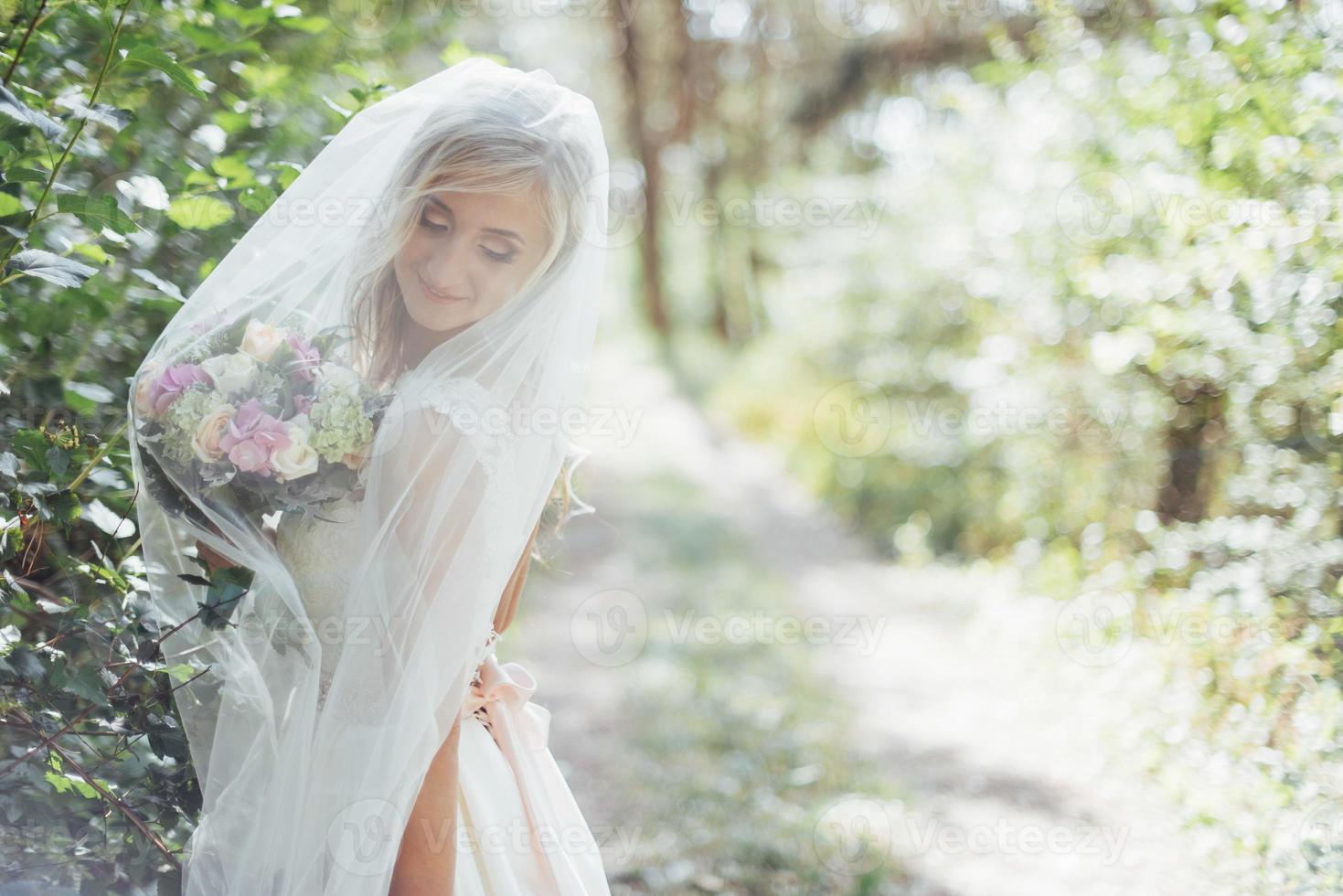 retrato de uma noiva feliz posando com véu foto