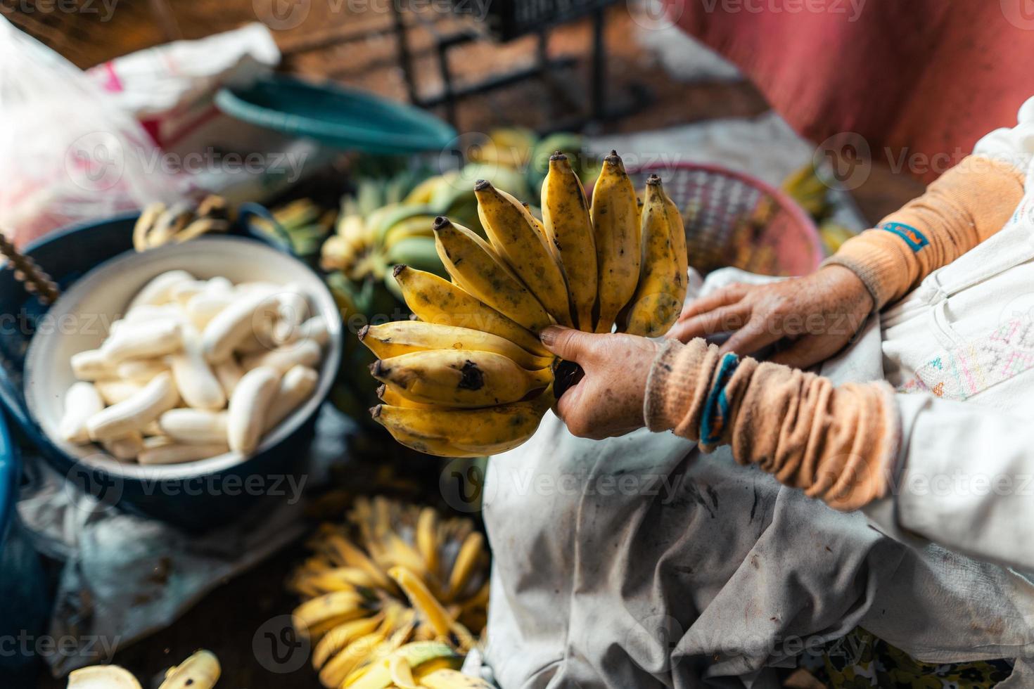 banana cultivada para processamento, banana na mão do vendedor foto