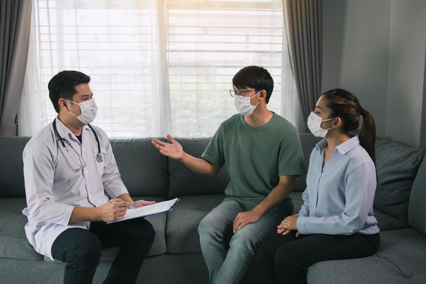 casal asiático está conversando com um médico sobre ter um bebê durante uma epidemia, além de pedir conselhos sobre como prevenir a doença durante a epidemia. foto