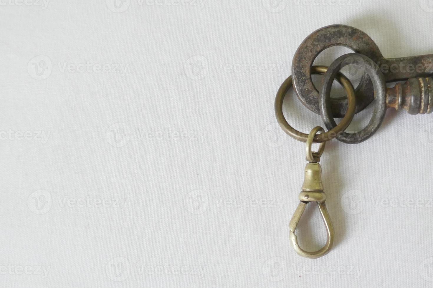 chaves de ferro velhas e chaveiro contra fundo branco foto