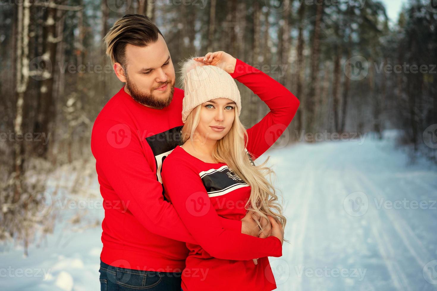 lindo casal jovem no inverno na floresta, abraço, romance feliz foto